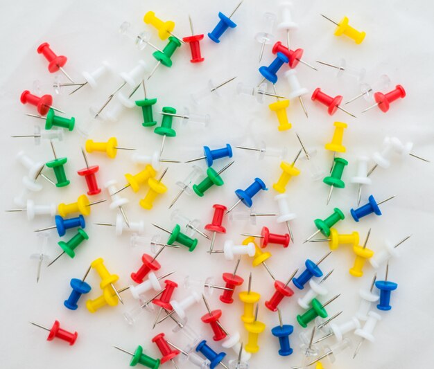 Multicolored office thumbtacks on white