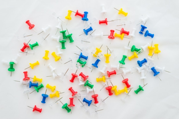 Multicolored office thumbtacks on white