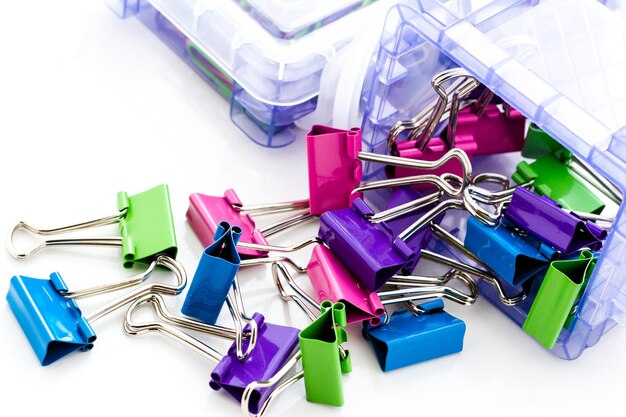 Multicolored paper clips in a pile on a white background.