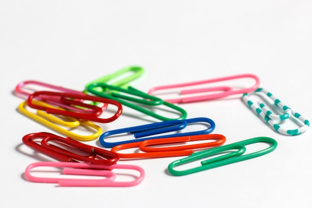 Multicolored paper clips on a white surface