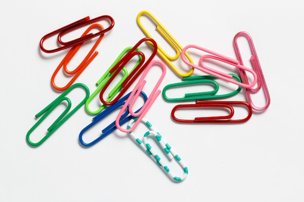 Multicolored paper clips on a white surface