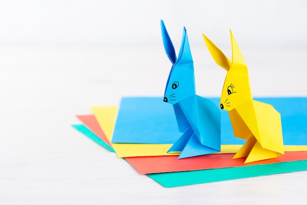 Multicolored paper rabbits on a light background