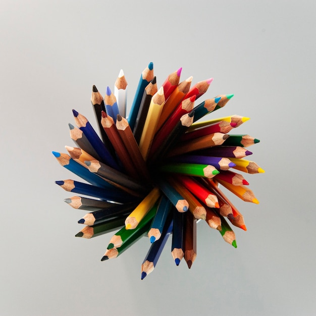 Multicolored pencils in a gray metal glass on a gray square