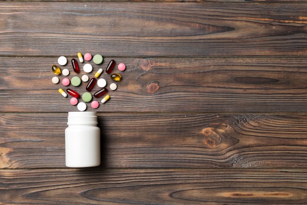 Multicolored pills and capsules in plastic bottle on Colored background copy space Many different various medicine tablets and pills vitamin and nutritional supplements concept