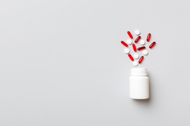 Multicolored pills and capsules in plastic bottle on Colored background copy space Many different various medicine tablets and pills vitamin and nutritional supplements concept