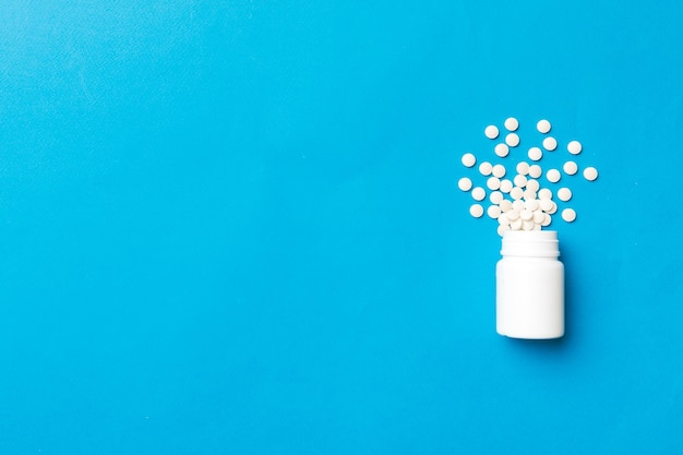 Multicolored pills and capsules in plastic bottle on Colored background copy space Many different various medicine tablets and pills vitamin and nutritional supplements concept