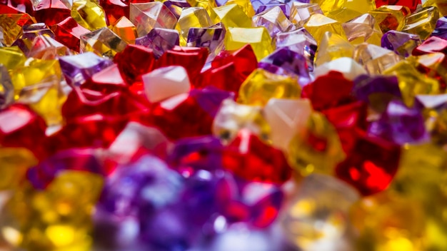 Multicolored plastic pebbles in bulk color background