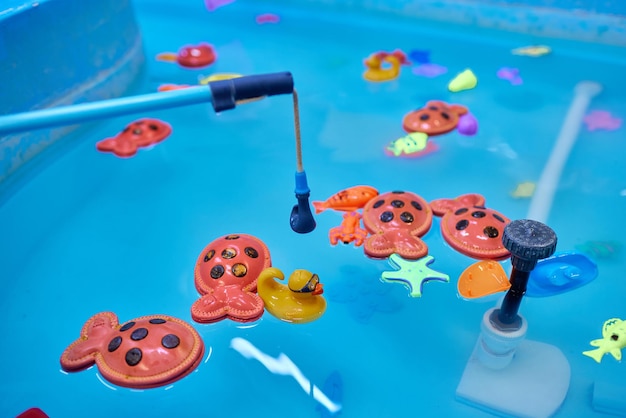 Multicolored plastic toy fish in pool for children's fishing concept game