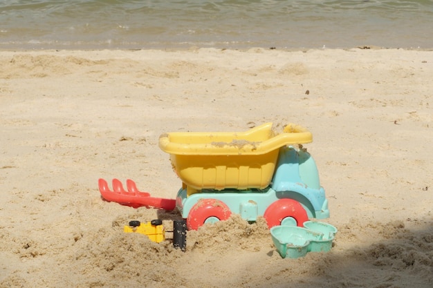 Multicolored plastic toys on a large sea sandy beach