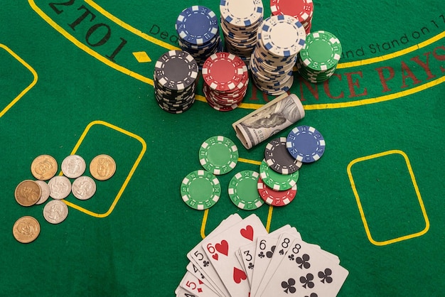 Multicolored poker cards chips dollar banknotes laid out on a new green poker table. Poker concept. Excitement concept