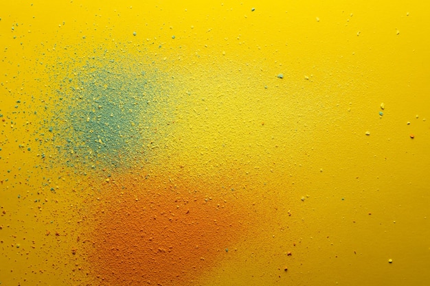 Multicolored powder orange green and yellow scattered on a bright background