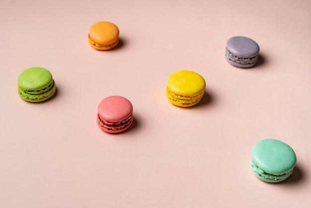 A multicolored set of french macaroons cookies on pastel background