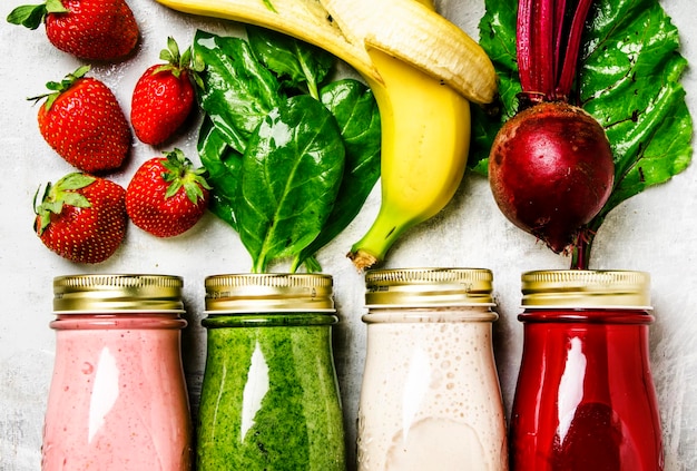 Multicolored smoothies and juices from vegetables fruits and berries food background top view