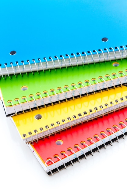 Photo multicolored spiral notebooks on a white background.