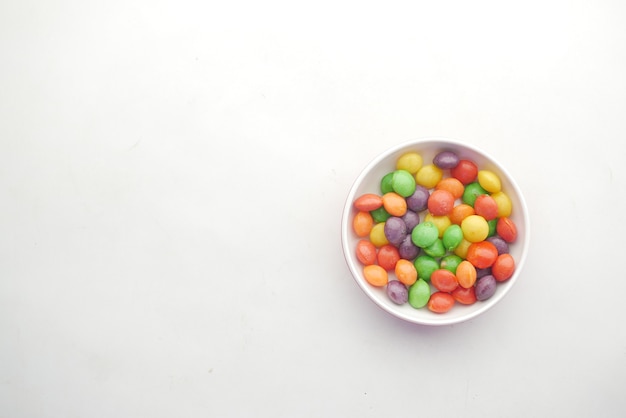 multicolored sweet candies in a bowl on white background