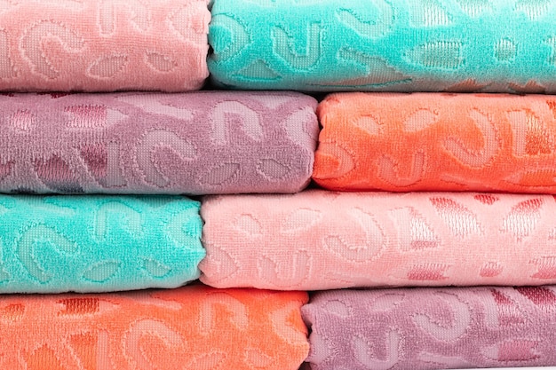 multicolored terry towels, rolled up and stacked on the table