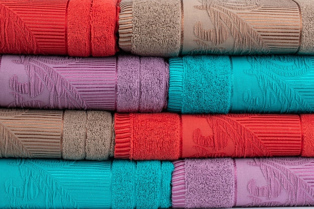 multicolored terry towels, rolled up and stacked on the table