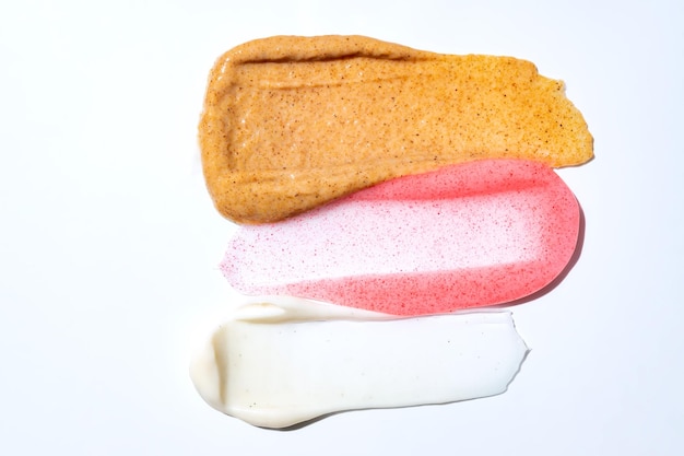 Multicolored texture of cream scrub with serum oil and hyaluronic acid on a white background Concept of cosmetics Smear of skincare cosmetics product