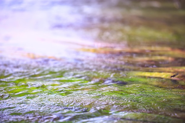 Photo multicolored texture surface of the water stream, clear water, colored stones at the bottom of the river