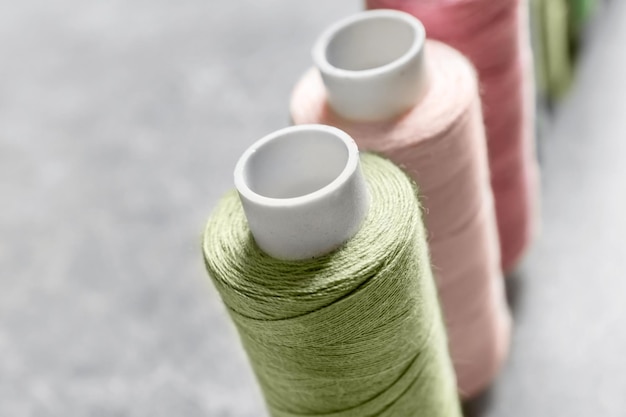 Photo multicolored threads on grey background closeup