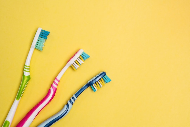 Multicolored toothbrushes copy space yellow