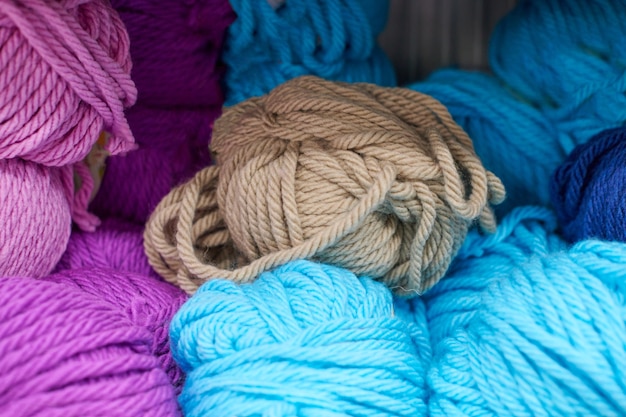 Multicolored yarn balls in knitting shop center, close up. A lot of color yarn for knitting. Colorful yarn wool on shopfront, macro.