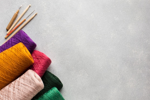 Multicoloured big sewing threads and grey copy space background