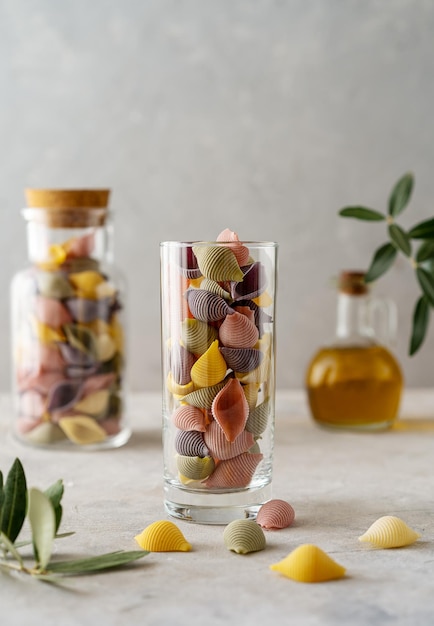 Multicoloured Italian pasta conchiglie or seashells in a glass