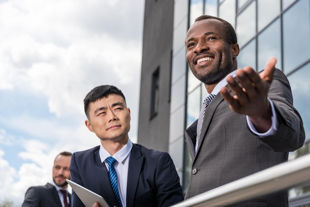 Multicultural business team meeting outdoors near office building