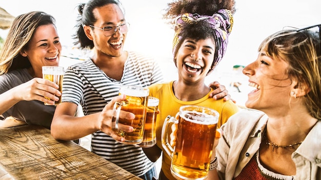 Multicultural friends cheering beer glasses together outside