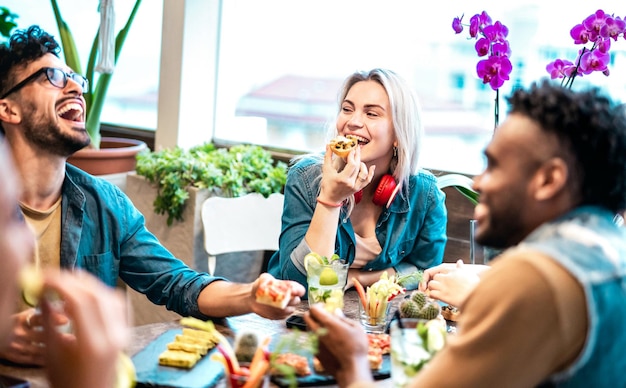 Multicultural friends eating together at luxury pub restaurant