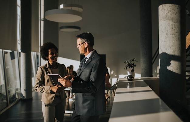 Multiethnic business people using digital tablet while standing in the office