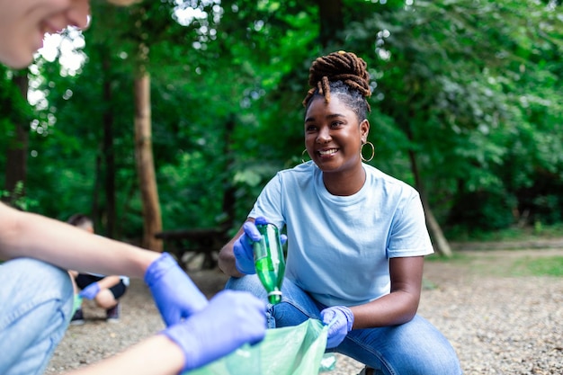 A multiethnic group of people cleaning together in a public park are protecting the environment The concept of recycling and cleaning