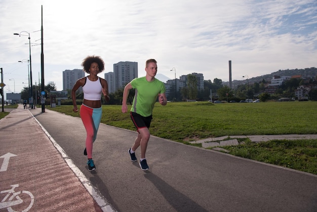 multiethnic group of young people on the jogging beautiful morning as the sun rises in the streets of the city