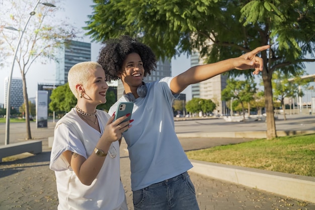 Multiethnic young couple pointing and talking happy on the modern university campus