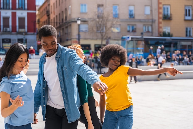 Multiethnic young friends dancing in the city authentic group of diverse friends having fun