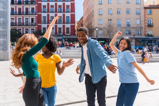 Multiethnic young friends dancing in the city having a good time together in the city