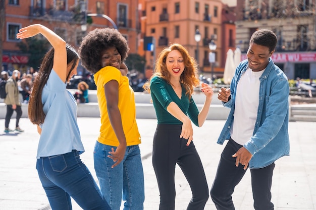 Multiethnic young friends dancing in a city square group dancers having fun