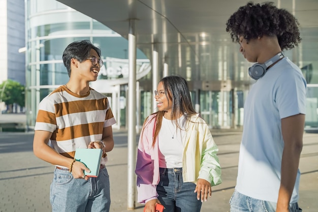 Multiethnic young friends walking and talking happy on the modern university campus