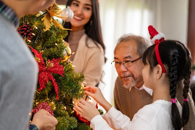 Multigenerational asian Family decorating a Christmas tree