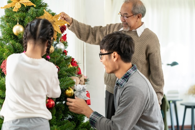 Multigenerational asian Family decorating a Christmas tree.