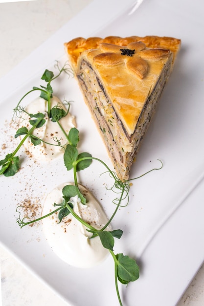 Multilayered meat and vegetable savory pie with a golden crust