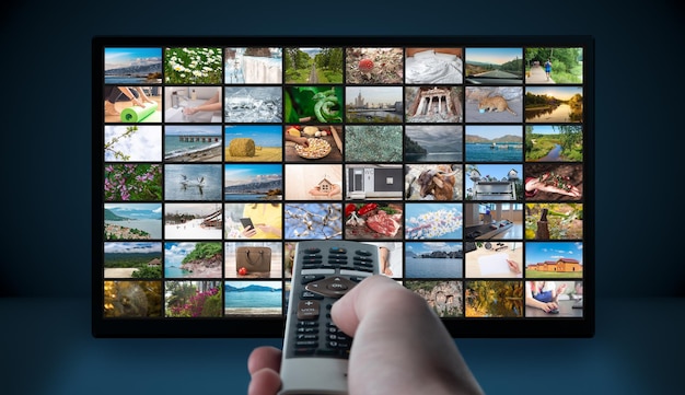 Multimedia Television video streaming Media TV on demand Subscription Streaming video Internet streaming service concept Man hand holding TV remote control