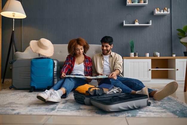 Multinational young family couple planning vacation trip on honeymoon with map