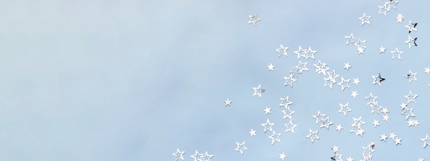 Multiple silver stars on blue background christmas banner