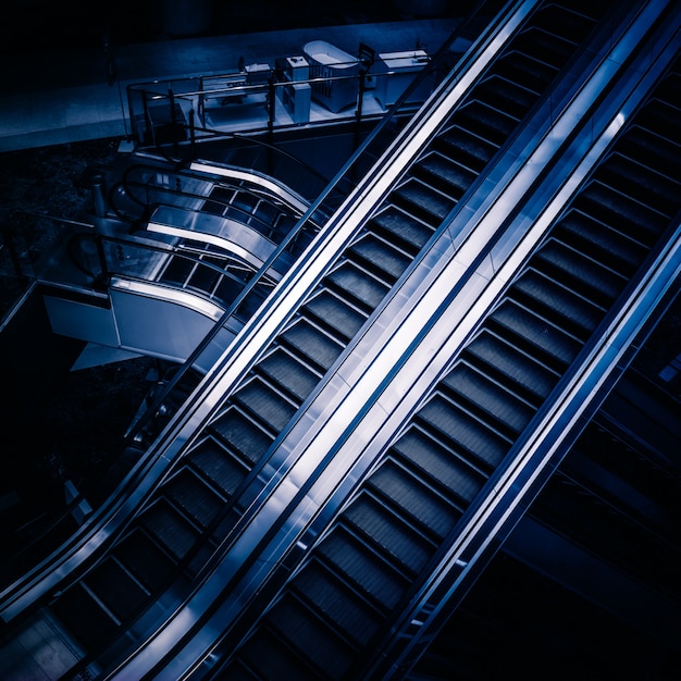 The multiple steps and directions of an escalator in the modern shopping mall , black and white background