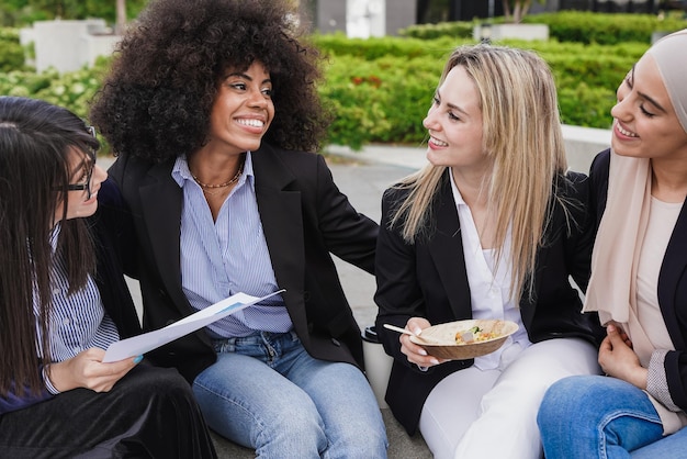 Multiracial business women having fun together during lunch break outside of office