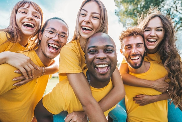 Multiracial community of young people smiling at camera outdoors