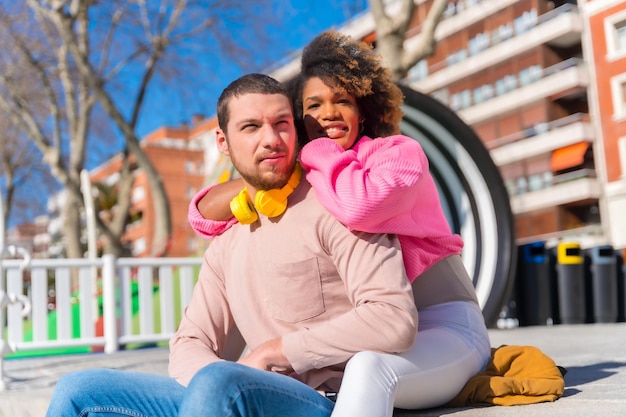 Multiracial couple on the streets of the city lifestyle hugging and looking at each other