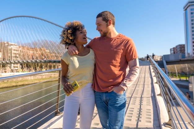 Multiracial couple through the city streets lifestyle enjoyed the weekend walking